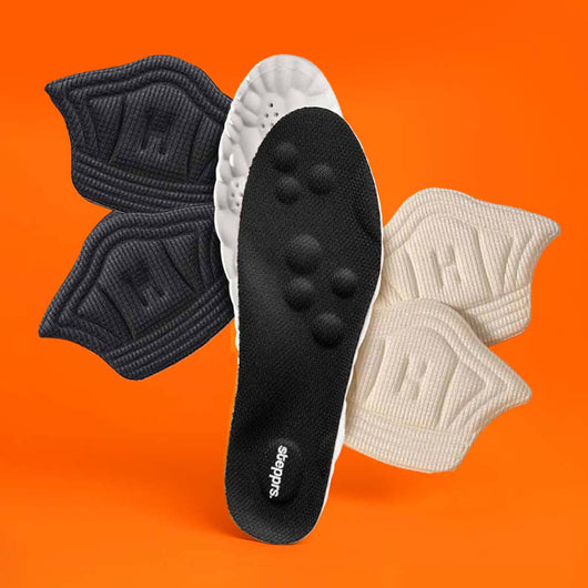 A black insole and fabric heel cushions floating against an orange backdrop.