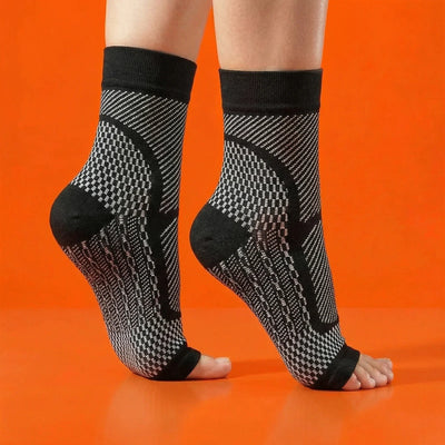 Black and white patterned ankle support socks on a person's legs against an orange background